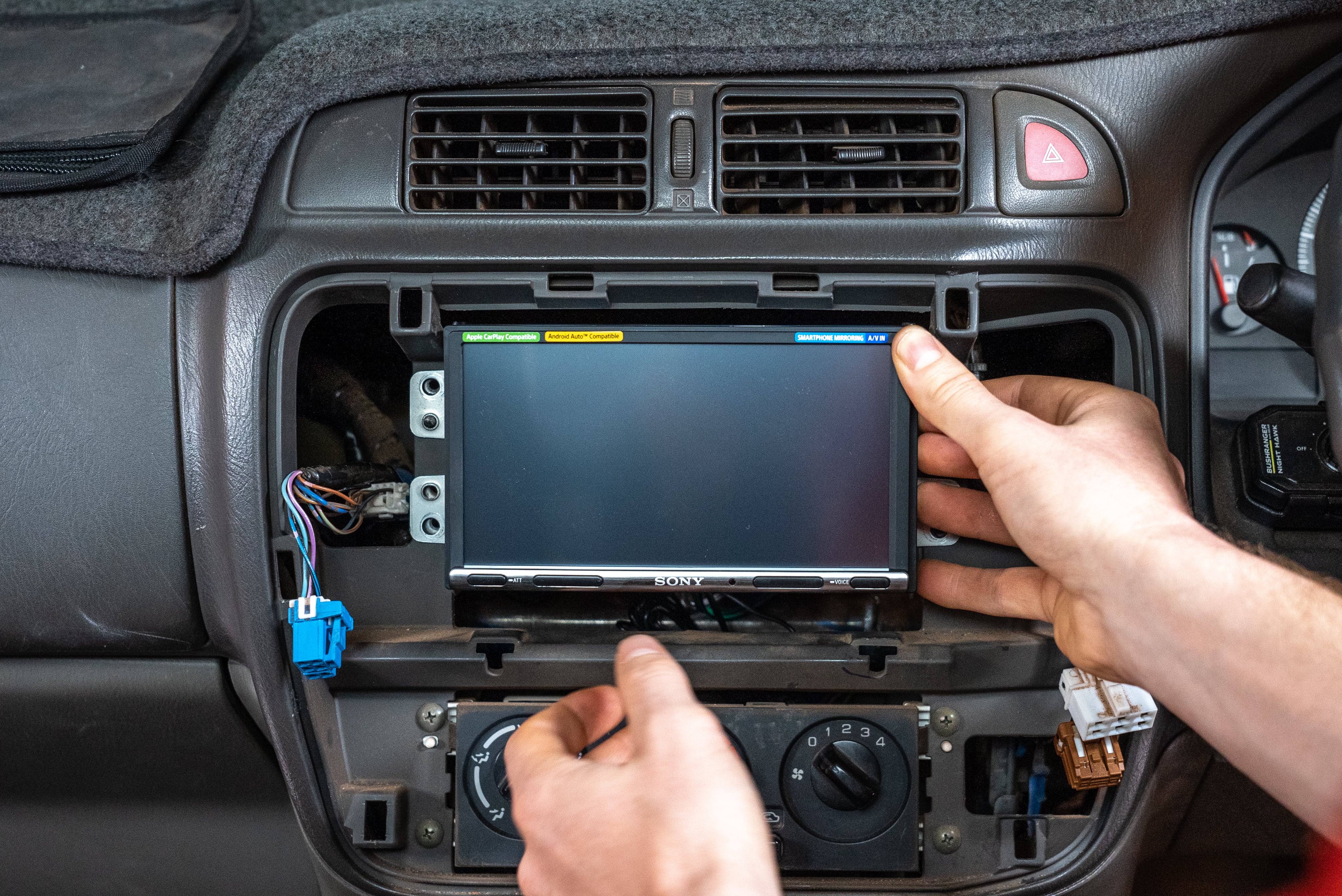 Installer fitting a new touchscreen stereo into a dashboard