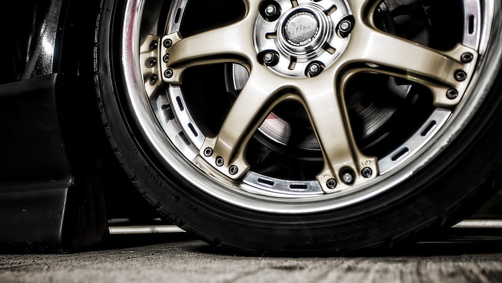 Gold custom wheel and low-profile tire on a car