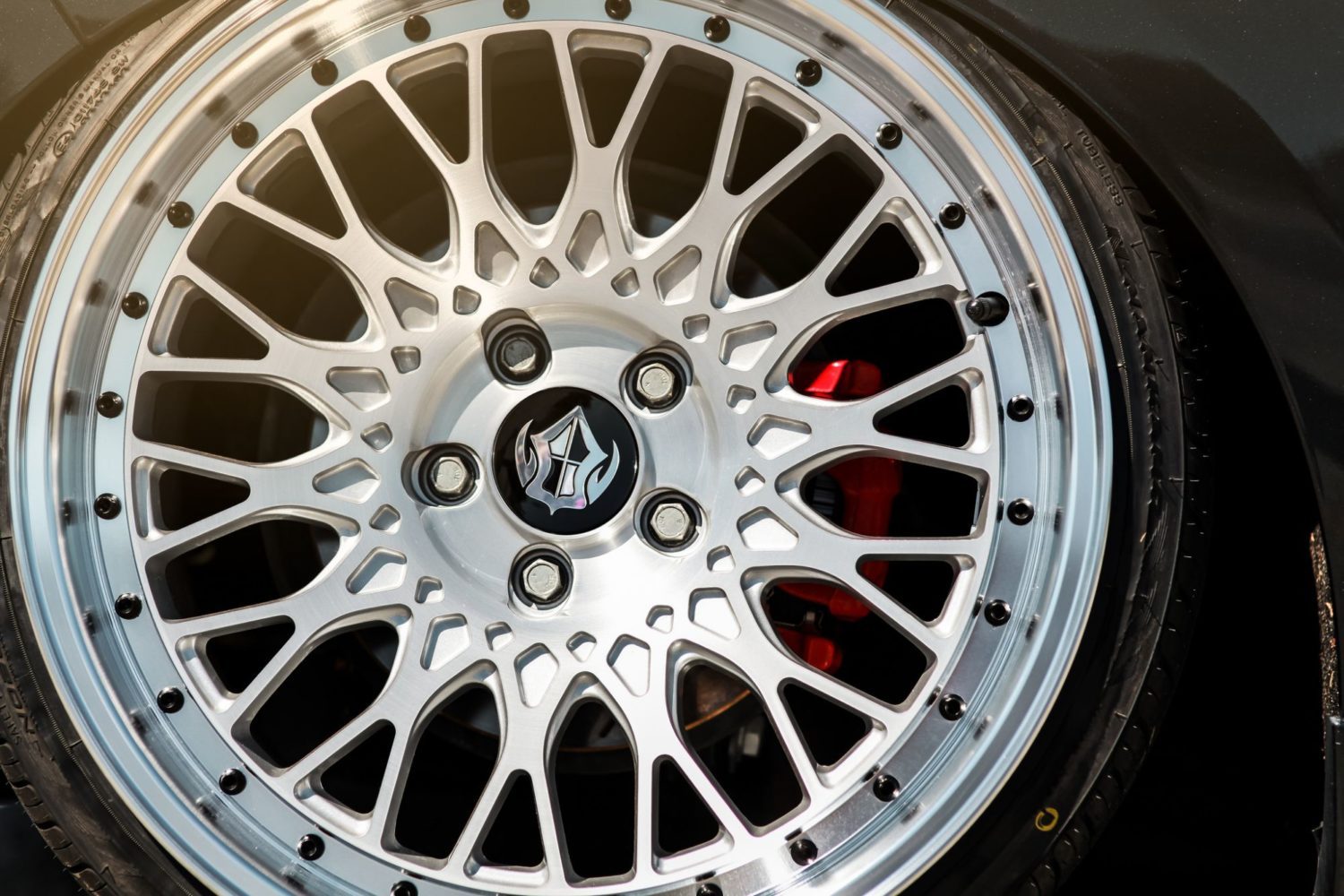 Silver custom wheel mounted on a red car
